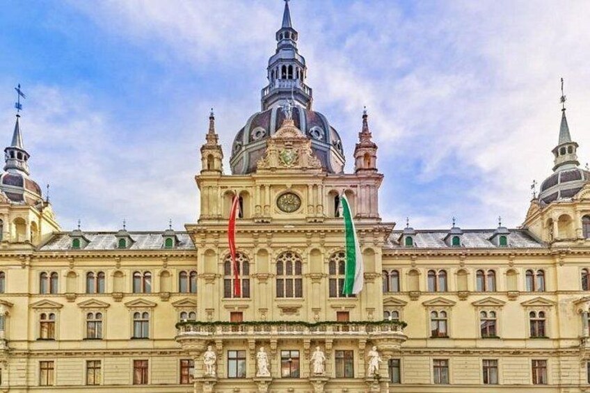 Un grande edificio storico con una cupola imponente e guglie, bandiere e statue. 5
