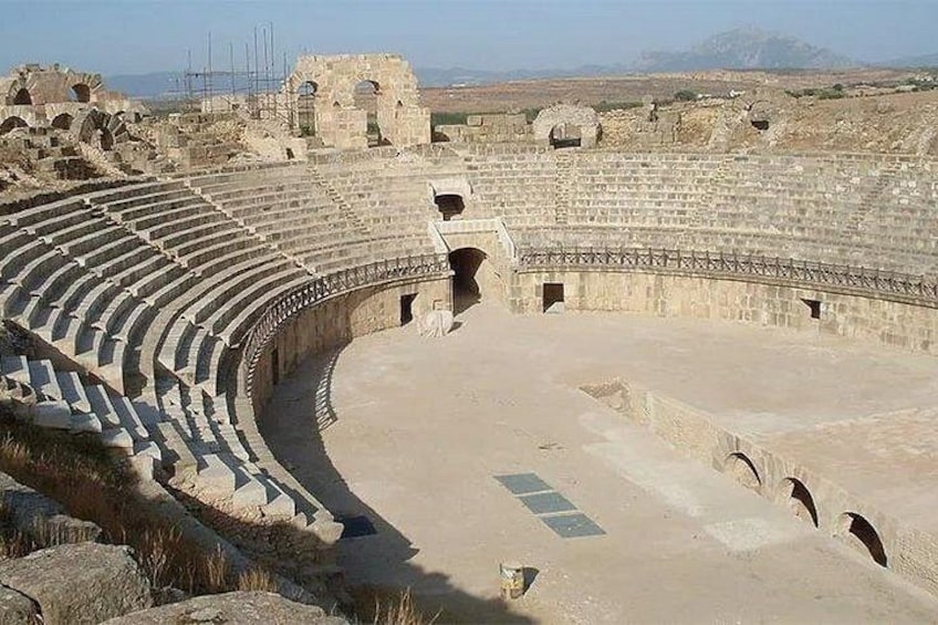 Un antico anfiteatro con posti a gradinate e un palcoscenico centrale. 2