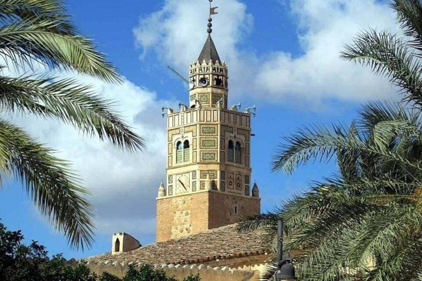 Un'antica torre dall'architettura elaborata, circondata da palme. 3