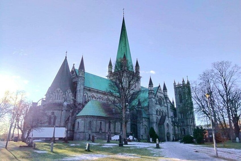 Een grote, historische kerk met een groen dak en meerdere torens. 5