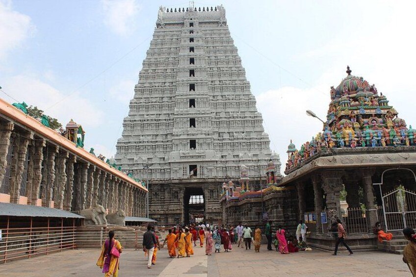 A temple with a tall, tiered gopuram, a large open courtyard, and a smaller shrine with colorful decorations. 4