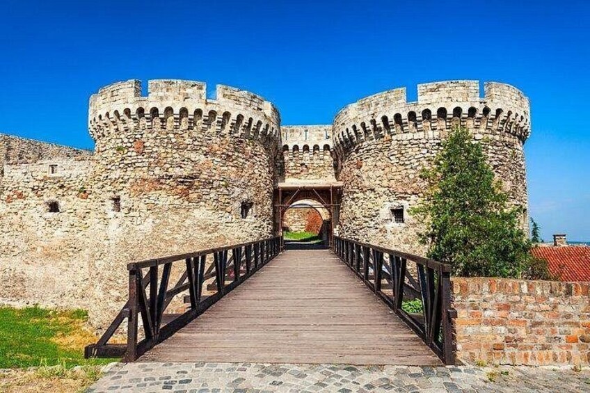 A stone castle with a wooden bridge leading to a central archway. 2