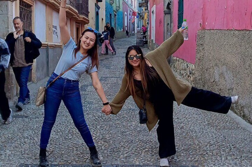 Two people holding hands and walking down a cobblestone street. 5