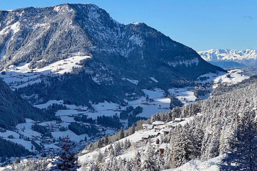 Paesaggio montano innevato con una valle e edifici sparsi. 3