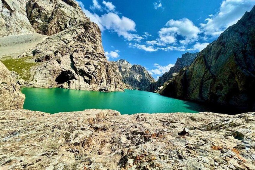 A turquoise lake surrounded by rocky mountains under a clear sky. 2