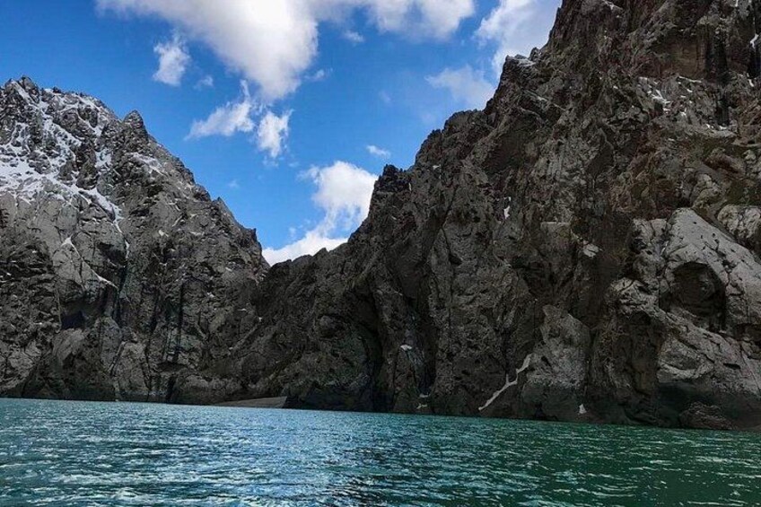 A rocky mountain landscape with a clear blue sky and calm water. 5