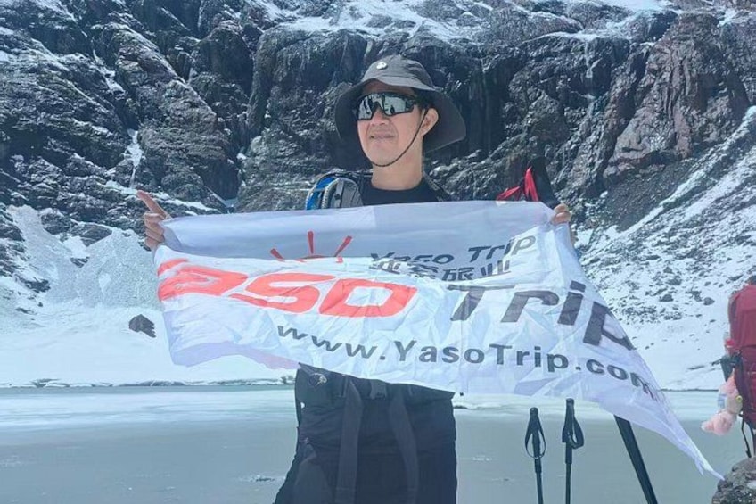 Una persona sosteniendo un cartel con el texto 'Yaso Trip' y una dirección web. 2