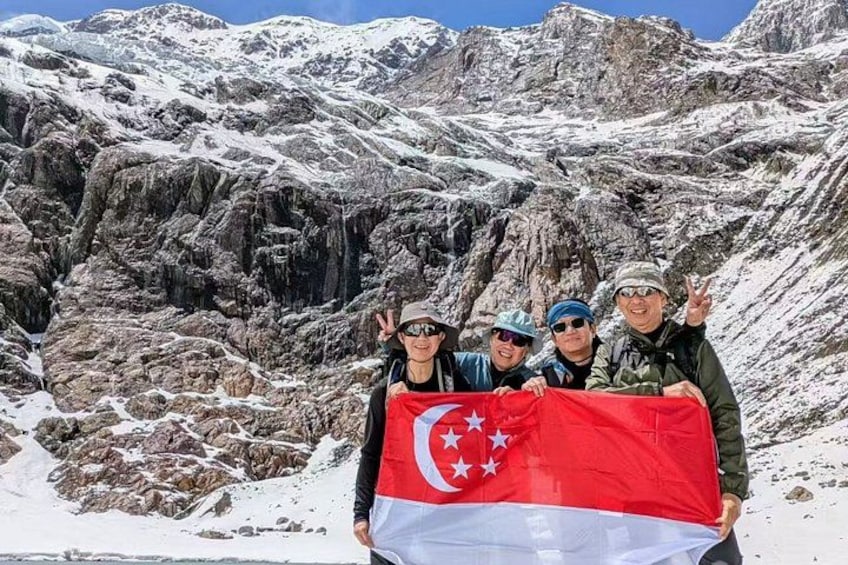 Un grupo de personas sostiene una bandera en una zona montañosa. 3