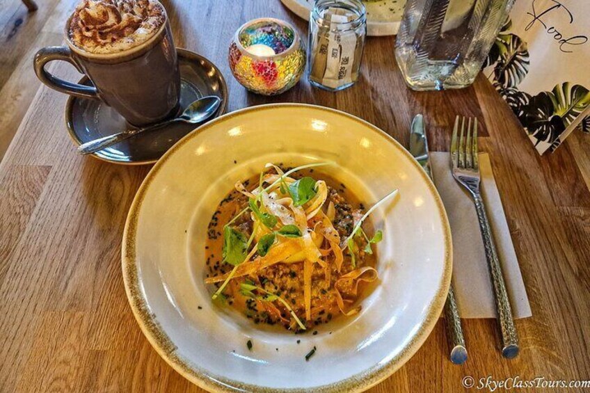 Un plato de comida con una taza de café sobre una mesa de madera. 3