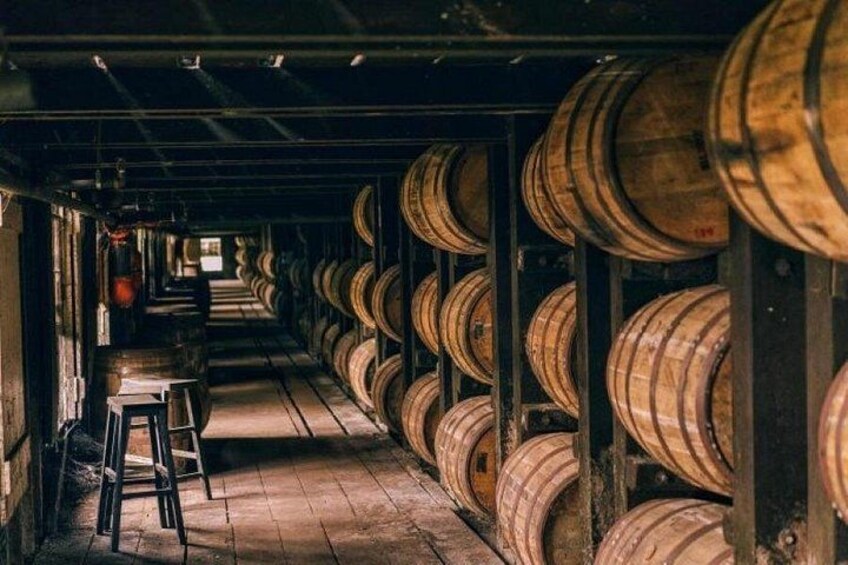 A warehouse with rows of wooden barrels. 5