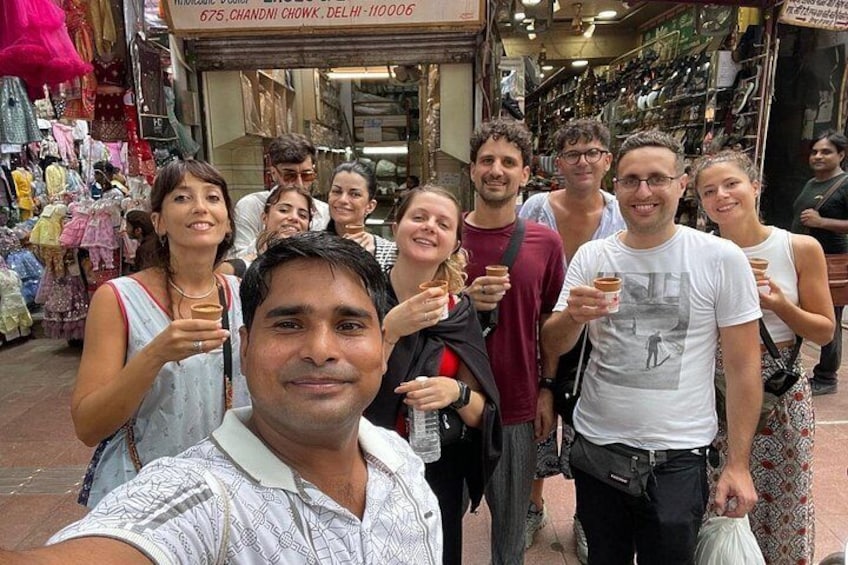 Een groep mensen op een markt, met verschillende kraampjes en koopwaar. 1