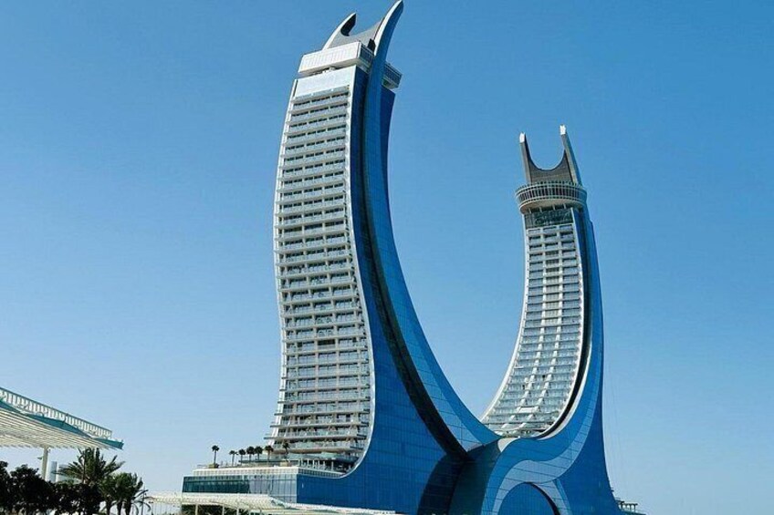 Une structure architecturale moderne au design incurvé, caractérisée par une tour imposante et une façade courbée. 2