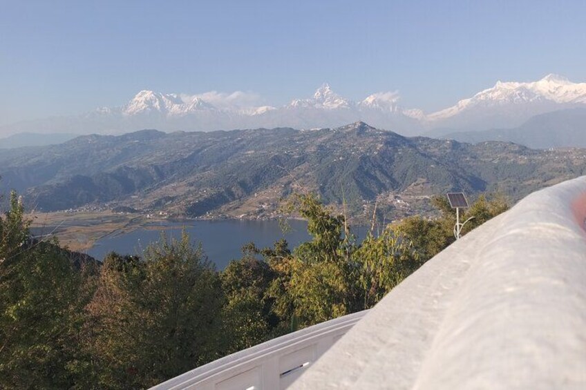 A mountainous landscape with a lake, snow-capped peaks, and a solar panel. 1