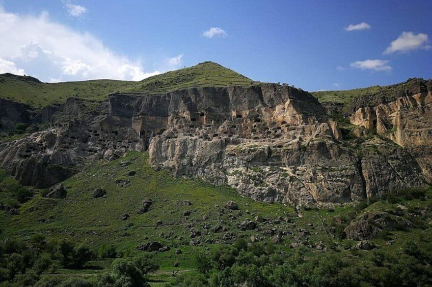 A mountainous landscape with rocky cliffs and green vegetation. 2