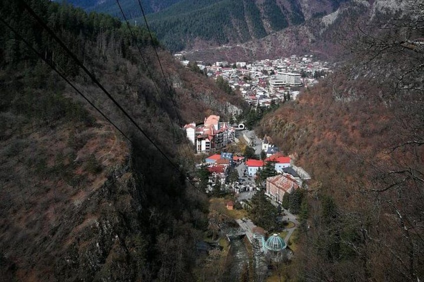 A valley with a town nestled among mountains, a winding road, and a prominent building with a dome. 4