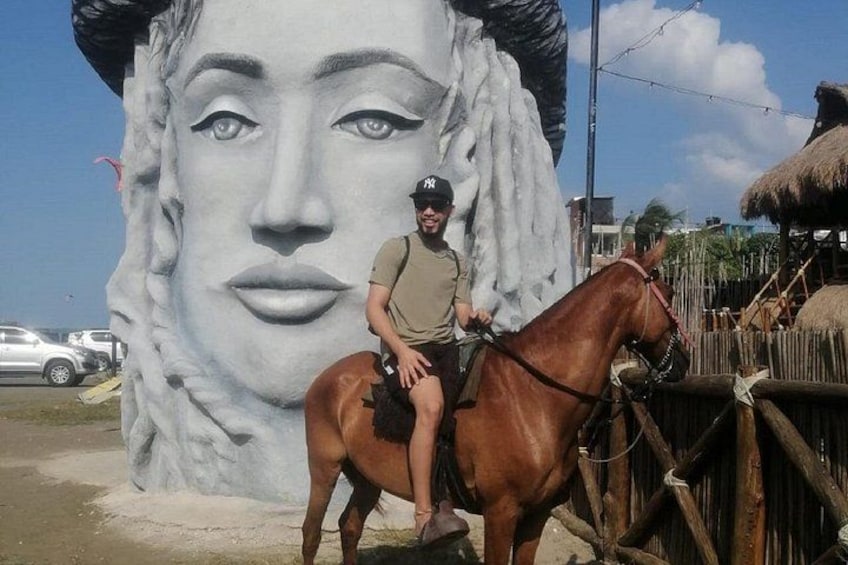 Une personne à cheval devant une grande fresque murale. 2