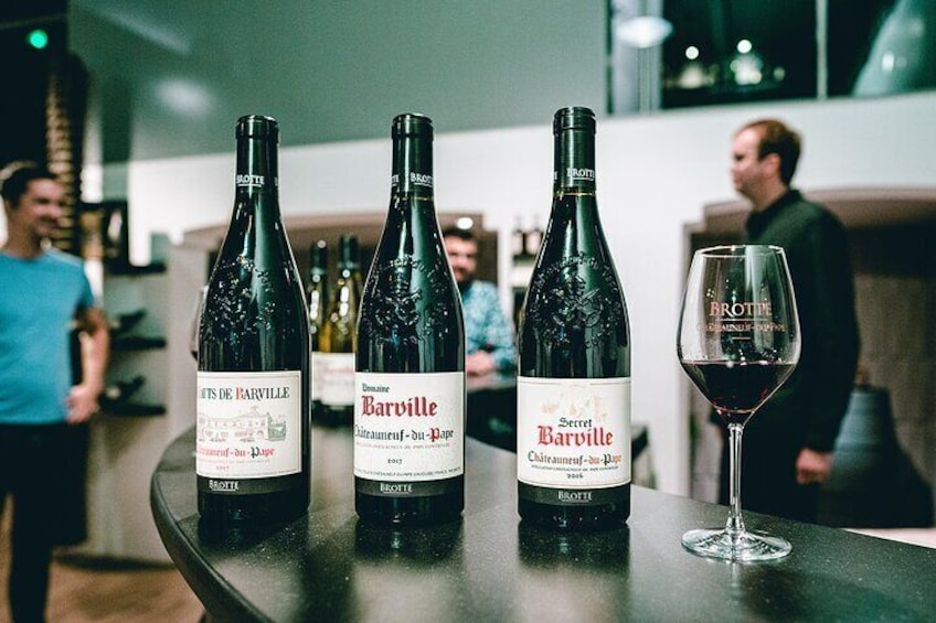 Three bottles of Barville wine and a glass of red wine on a table in a restaurant. 5