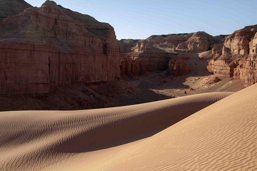 A desert landscape with sand dunes and rock formations. 2