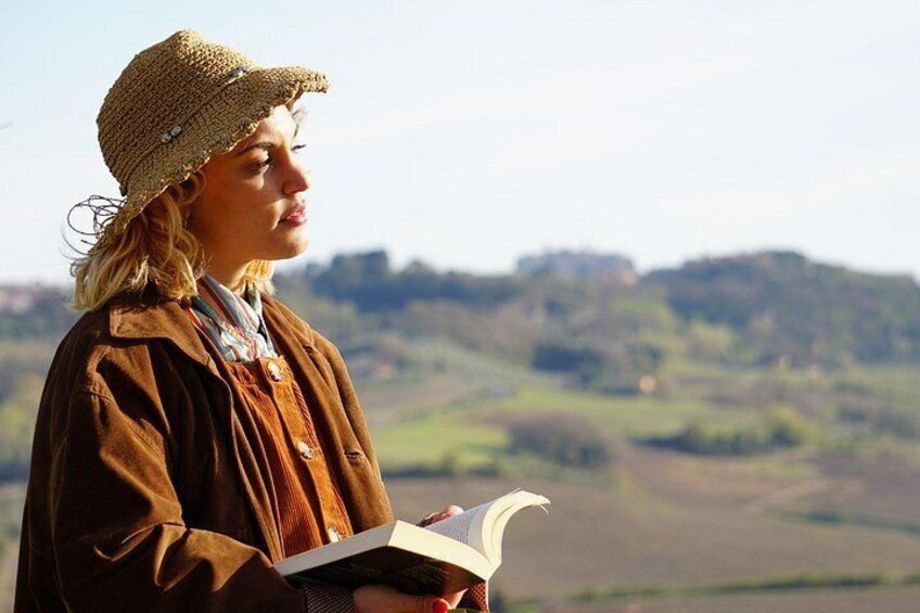 A person reading a book with a scenic landscape in the background. 5
