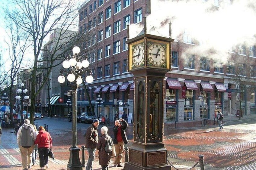 A public square with a clock tower, pedestrians, and buildings in the background. 5