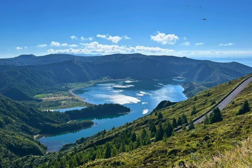 Un paysage montagneux avec un lac, une route sinueuse et un ciel dégagé. 1