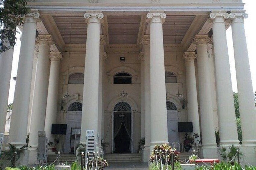 A grand building with large columns, an arched entrance, and a covered walkway. 5
