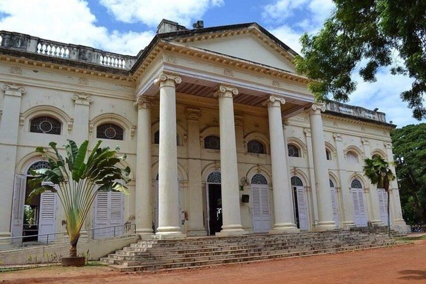 A classical building with columns, a portico, and a staircase leading to the entrance. 2