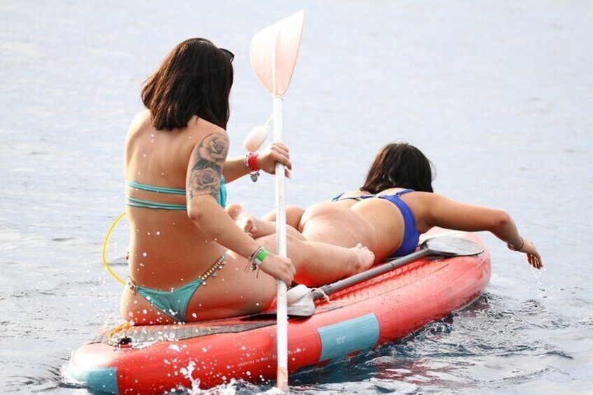 Two people on a red inflatable raft in the water. 3