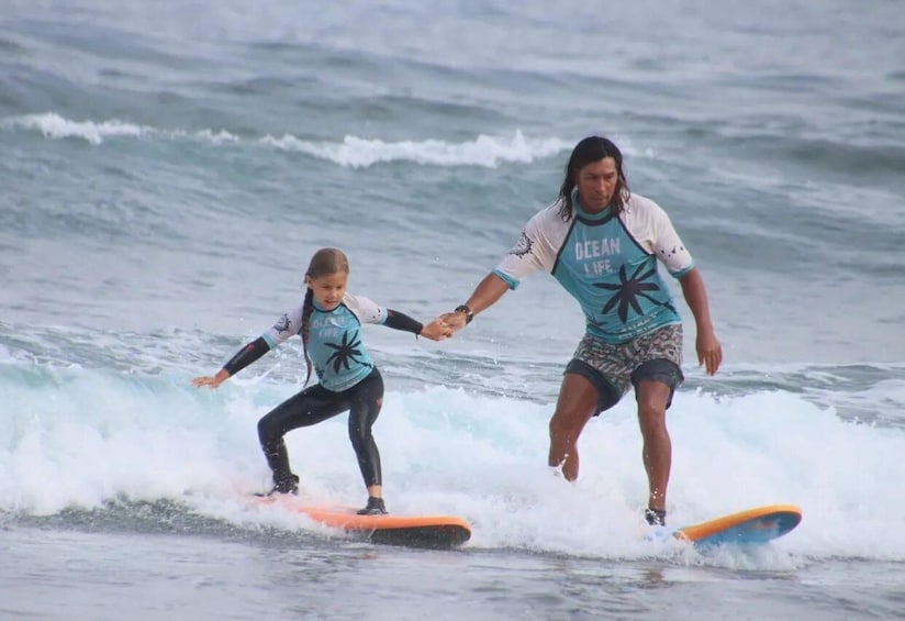 Two people surfing on a wave. 1