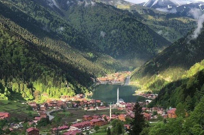 Eine Berglandschaft mit einem See, einer Kirche und einem kleinen Dorf. 4