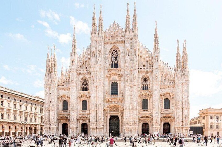 A large, ornate cathedral with multiple spires and a crowd of people in front. 2