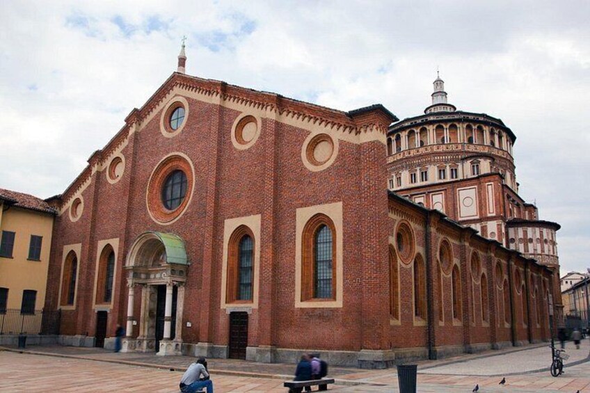 A large brick building with arched windows and a dome. 3