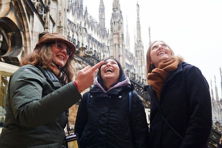 Three people standing in front of a historic building with Gothic architecture. 5