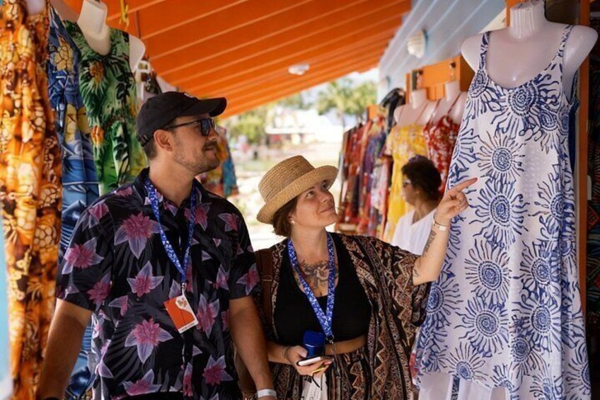 A market stall with colorful fabrics and a mannequin in a patterned dress. 5