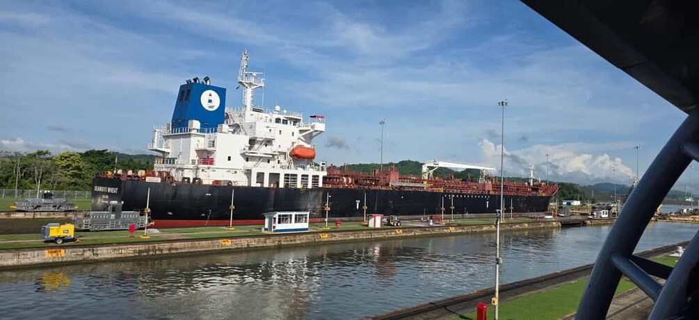 Un gran buque de carga atracado en un puerto bajo un cielo despejado. 5