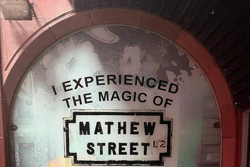 A circular window with a sign that reads 'I experienced the magic of Mathew Street.' 5