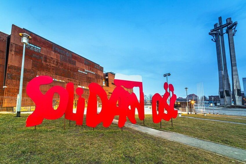 Een groot, rood beeld met de tekst 'Solidaridad' voor een modern gebouw. 4