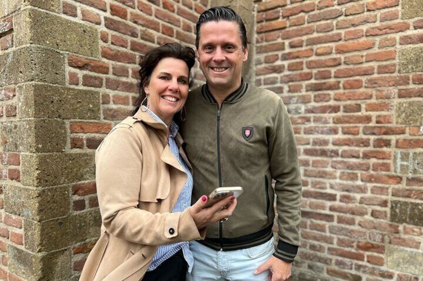 Ein Mann und eine Frau stehen vor einer Ziegelwand. 1