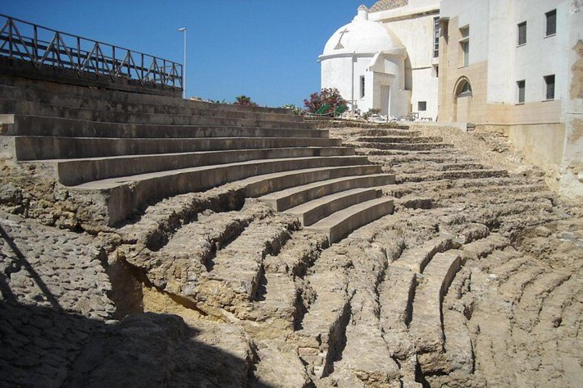 Un ancien amphithéâtre avec des gradins en pierre menant à une scène centrale. 2