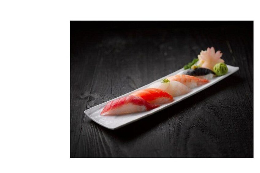 A sushi dish on a rectangular plate with a black background. 2
