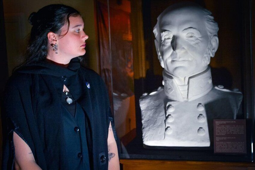 Una persona de pie junto a un busto en una vitrina. 4
