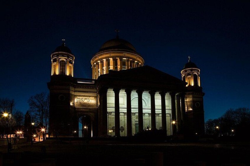 A grand building with a large dome and two towers, illuminated at night. 5