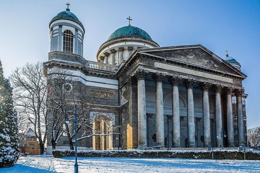 A large, historic building with domed roofs and columns, surrounded by snow. 3