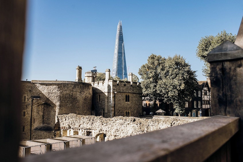 Un edificio histórico de piedra con una torre alta y un rascacielos moderno al fondo. 5