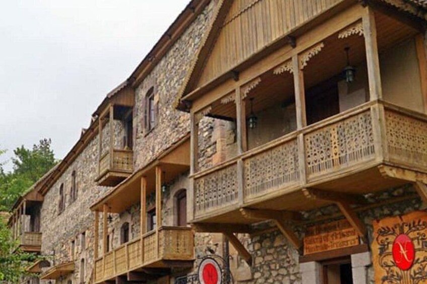 A stone building with wooden balconies and a clock. 1