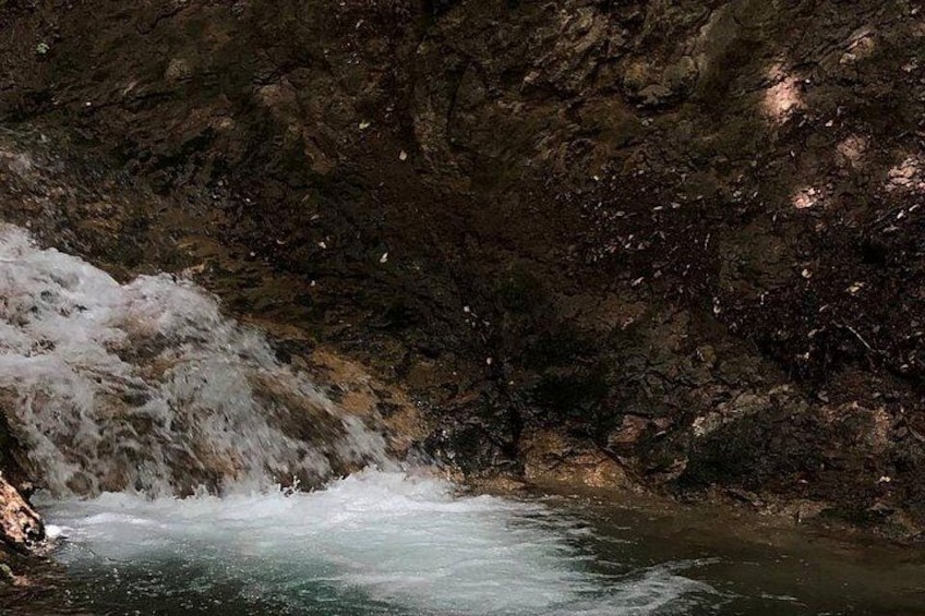 A cave with a flowing water stream and rocky walls. 3