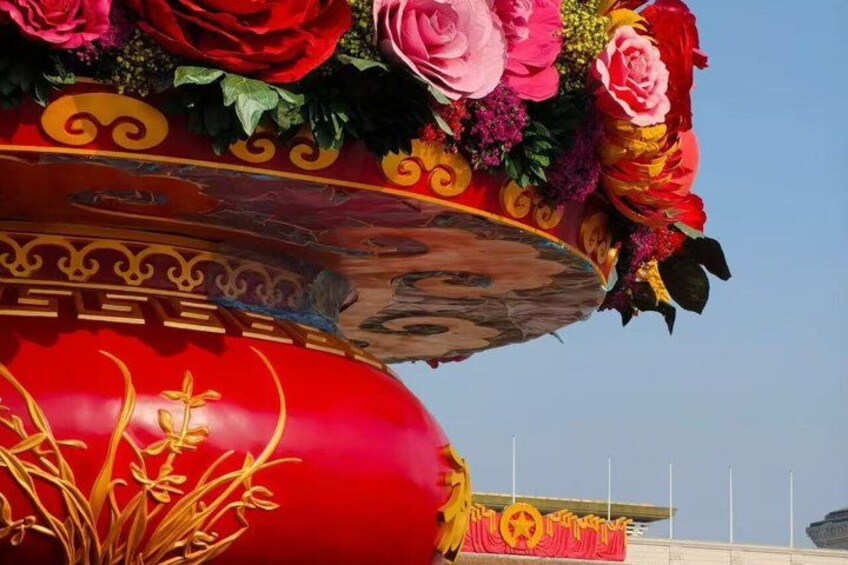 Een rode decoratieve constructie met gouden patronen en een bloemstuk. 2