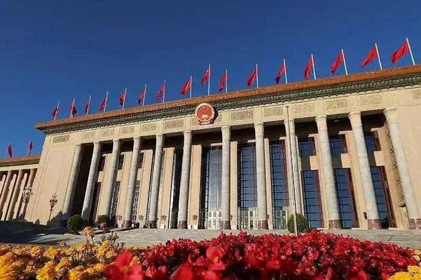 Un grande edificio con una fila di bandiere sulla sommità e uno stemma rosso al centro. 3