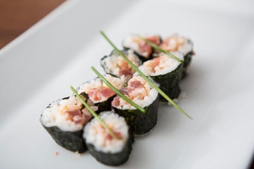 Sushi rolls with shrimp and green garnish on a white plate. 2