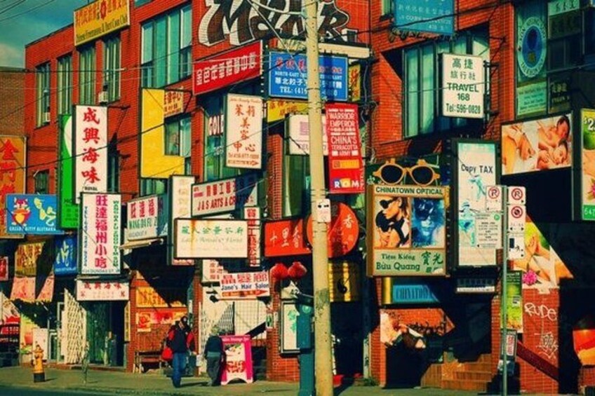 A street with multiple colorful signs and advertisements on buildings. 2